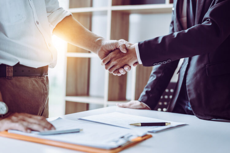 Middle age partner lawyers attorneys shaking hands after discussing a contract agreement done, Asian people.