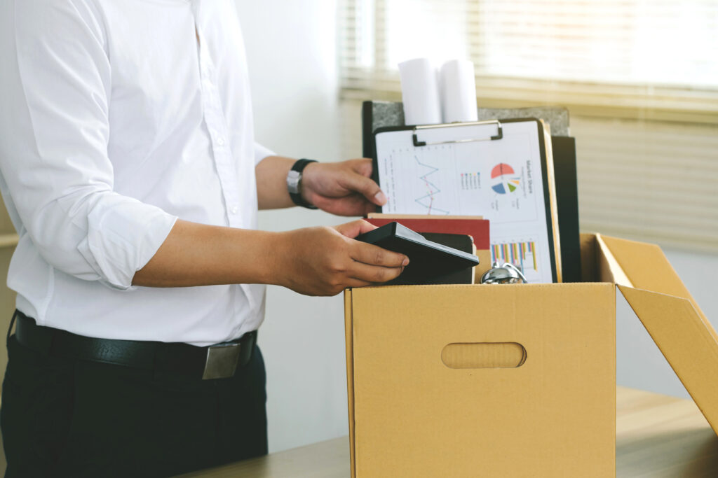 Businessmen packing Stuff Resign Depress or carrying business cardboard box by the desk in the office. Quitting a job, The big quit. The great Resignation